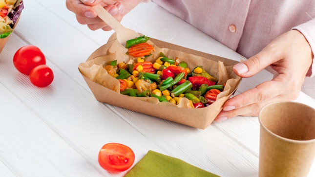 Woman Eating Steamed Vegetables in a Kraft Paper Food Container
