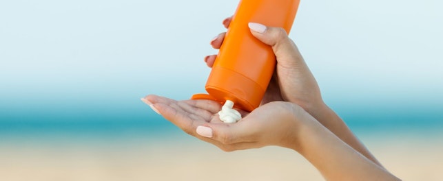 Woman Hand Apply Sunscreen on the Beach