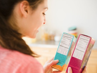 Woman Reading Food Nutritional Facts on Packaging