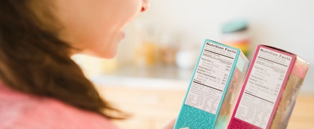 Woman Reading Food Nutritional Facts on Packaging