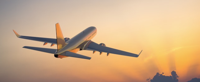 Aircraft Flying Above Clouds at Sunset