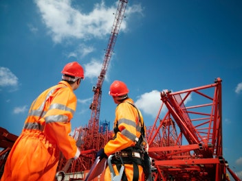 Crane Workers Looking at Cranes