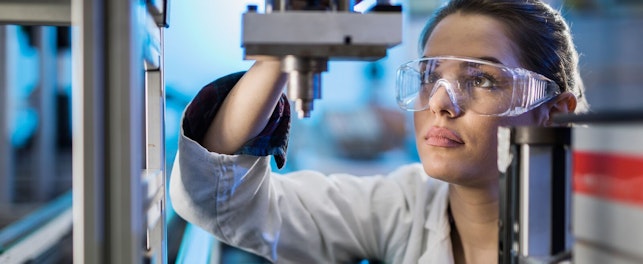 Engineer Examining Machine Part on a Production Line