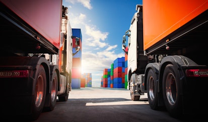 Semi trailer Trucks on The Parking Lot with Stacked Containers