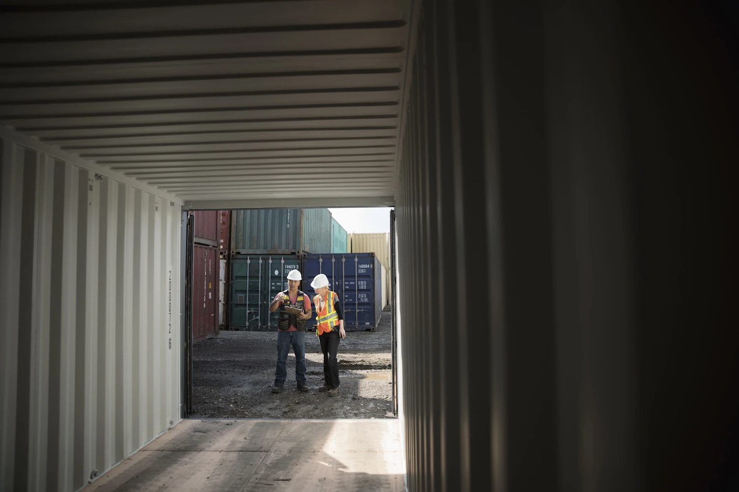 Workers Inspecting Empty Shipping Container