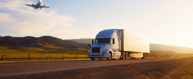 Airplane and Truck on highway at sunset