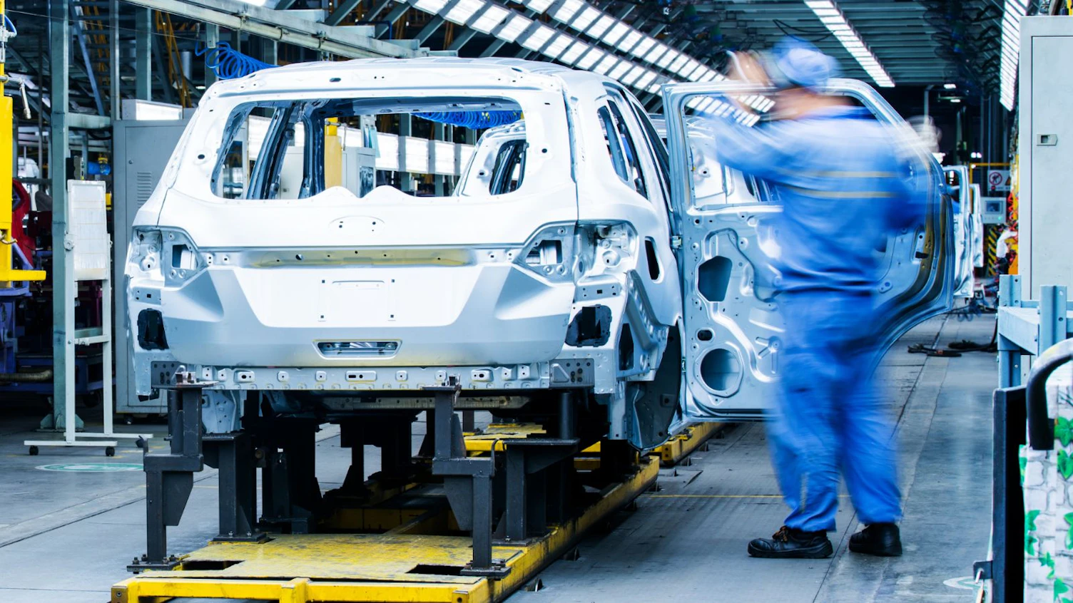 Auto Factory Workers Working on Automobile Assembly