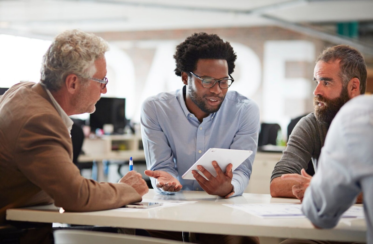Business Colleagues Discussing a Project Using Tablet