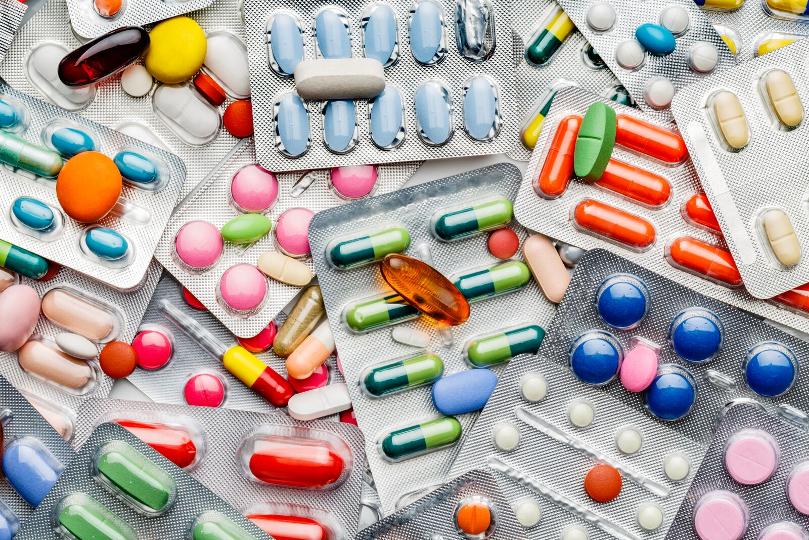 Health themes. Background of a large group of assorted capsules, pills and blisters. Drug abuse.