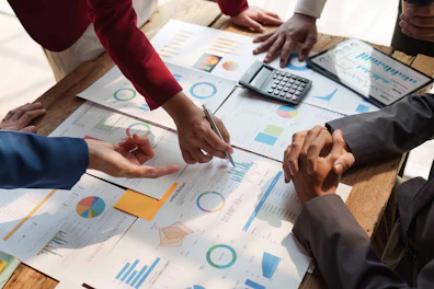 Close up of Diverse colleagues gather brainstorm discuss financial statistics at office meeting. finance, teamwork, Big data Graphs Charts concept.