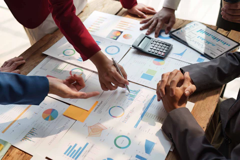 Close up of Diverse colleagues gather brainstorm discuss financial statistics at office meeting. finance, teamwork, Big data Graphs Charts concept.