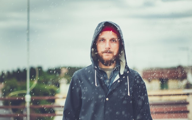Man with Raincoat under Heavy Rain