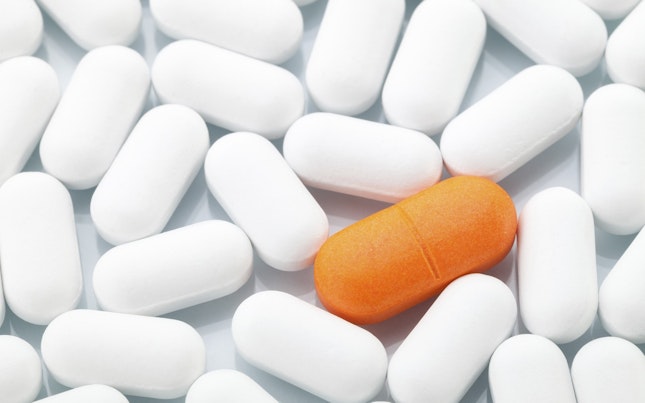 Orange pill amongst white pills