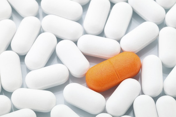 Orange pill amongst white pills