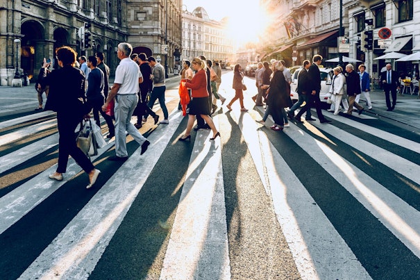 Personas cruzando la calle con la luz del sol