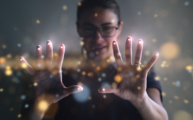 Mujer con luz en las yemas de los dedos