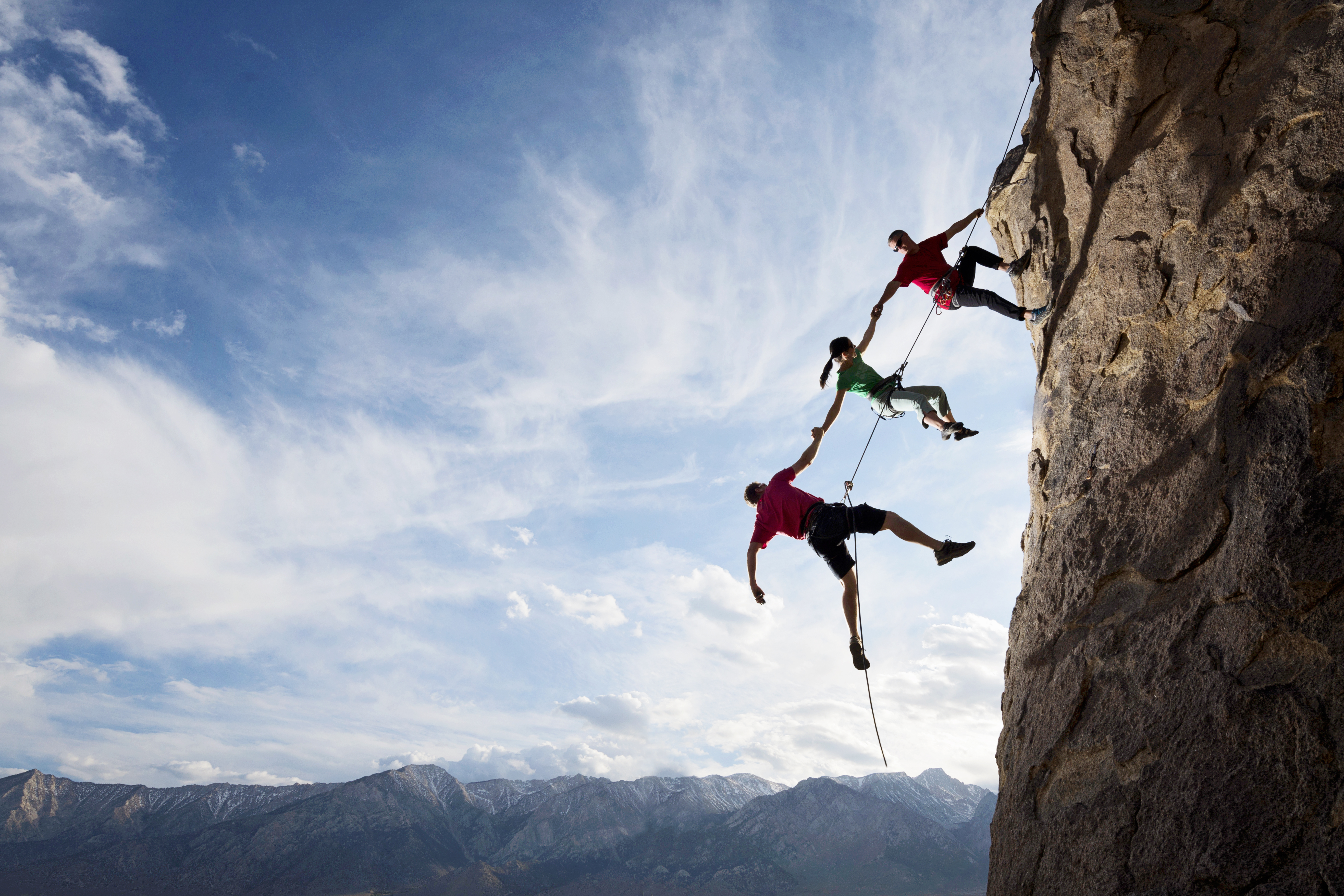 Rock Climbers Helping One from Falling