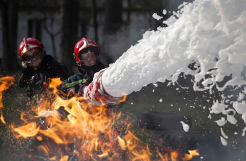 Feuerwehrleute löschen ein Feuer mit Schaum