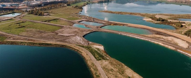 aerial-shot-landscape-surrounded-by-mountains-lakes-with-industrial-disaster 1
