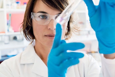 Chemist looking at liquid in test tube