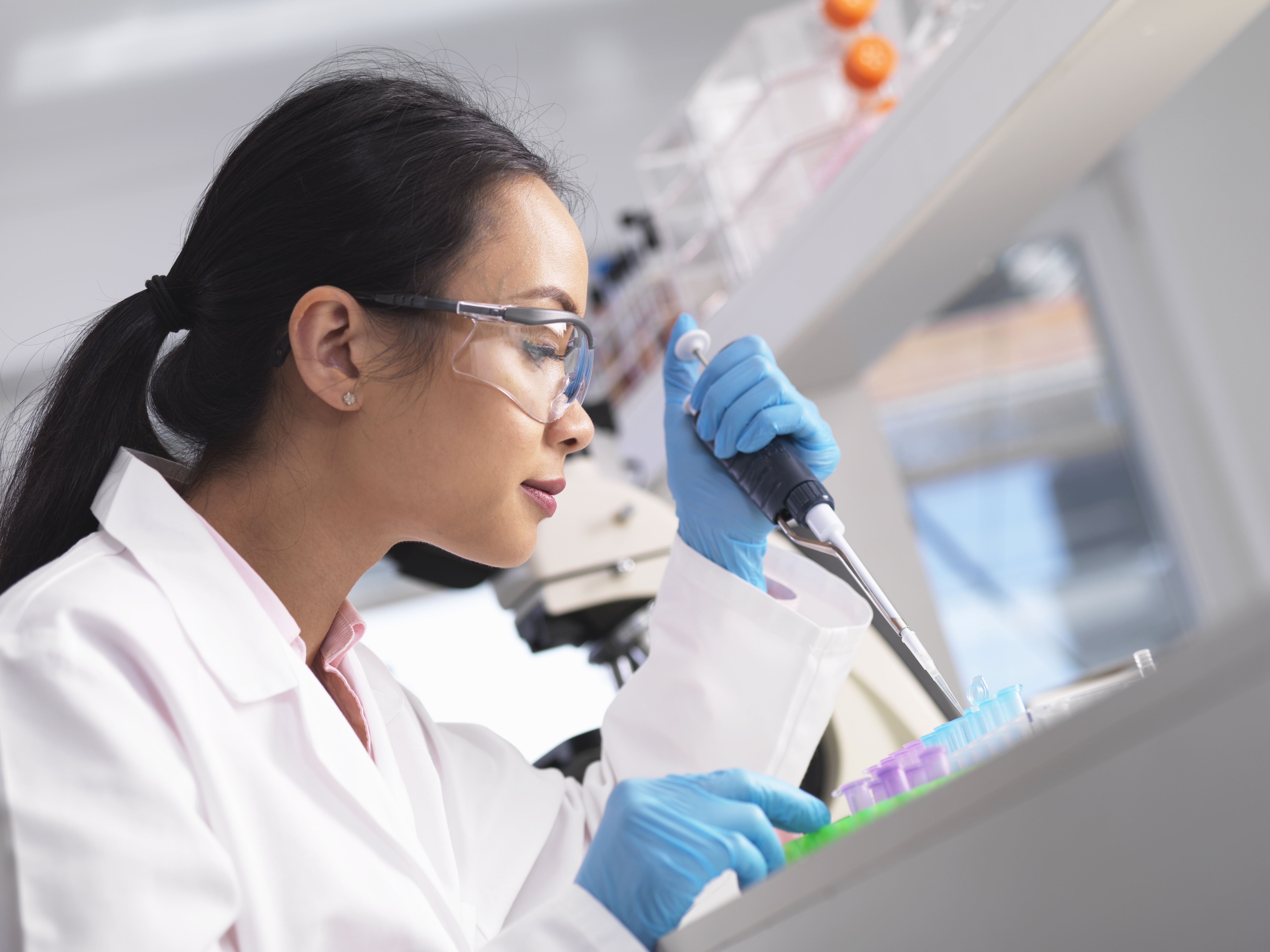A scientist is pipetting a sample in the laboratory 