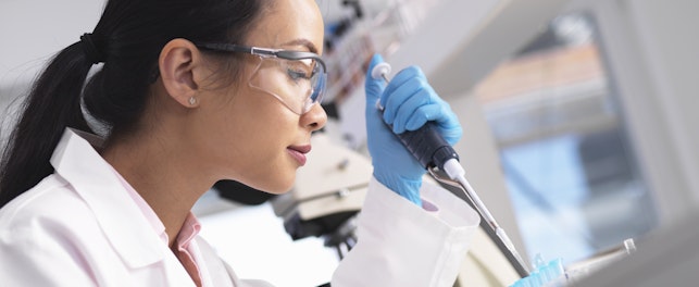 Tutkija pipetöi näytettä laboratoriiossa