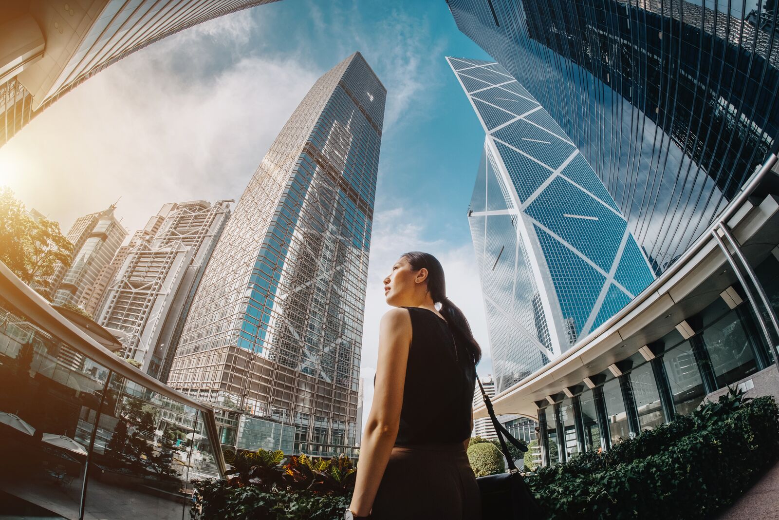 Fish Eye Shot of a Businesswoman Standing amongst High Buildings