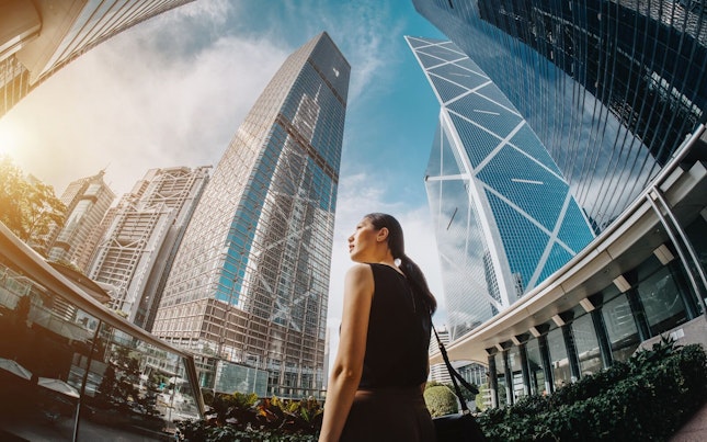 Fish Eye Shot of a Businesswoman Standing amongst High Buildings
