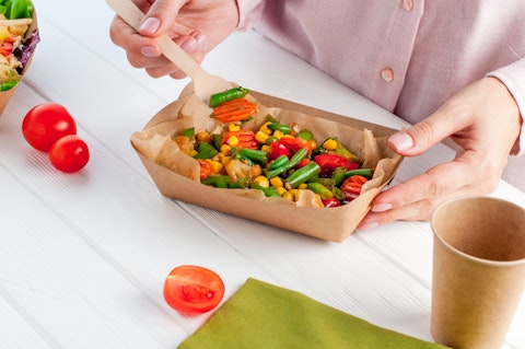 Woman Eating Steamed Vegetables in a Kraft Paper Food Container