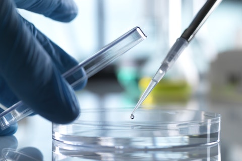 scientist pipetting sample into petri dish in laboratory