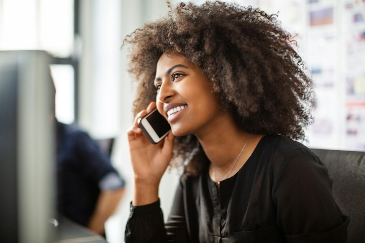 Businesswoman Using her Phone while Working at her Desk
