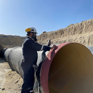 Worker Standing on Pipeline