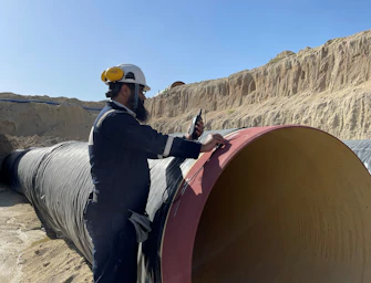 Worker Standing on Pipeline