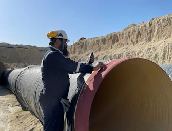 Worker Standing on Pipeline