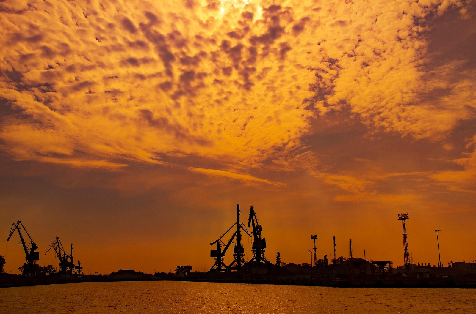 Zarys portu morskiego w świetle zachodzącego słońca.