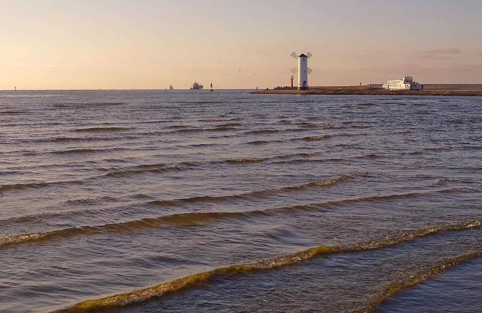 Morze Bałtyckie z widocznymi w tle statkami i latarnią morską.
