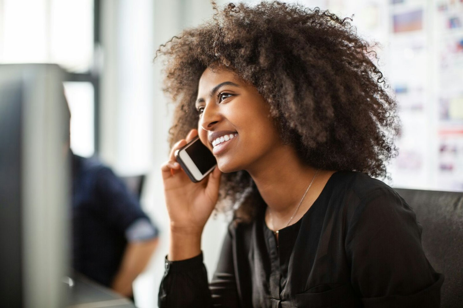 Businesswoman Using her Phone while Working at her Desk