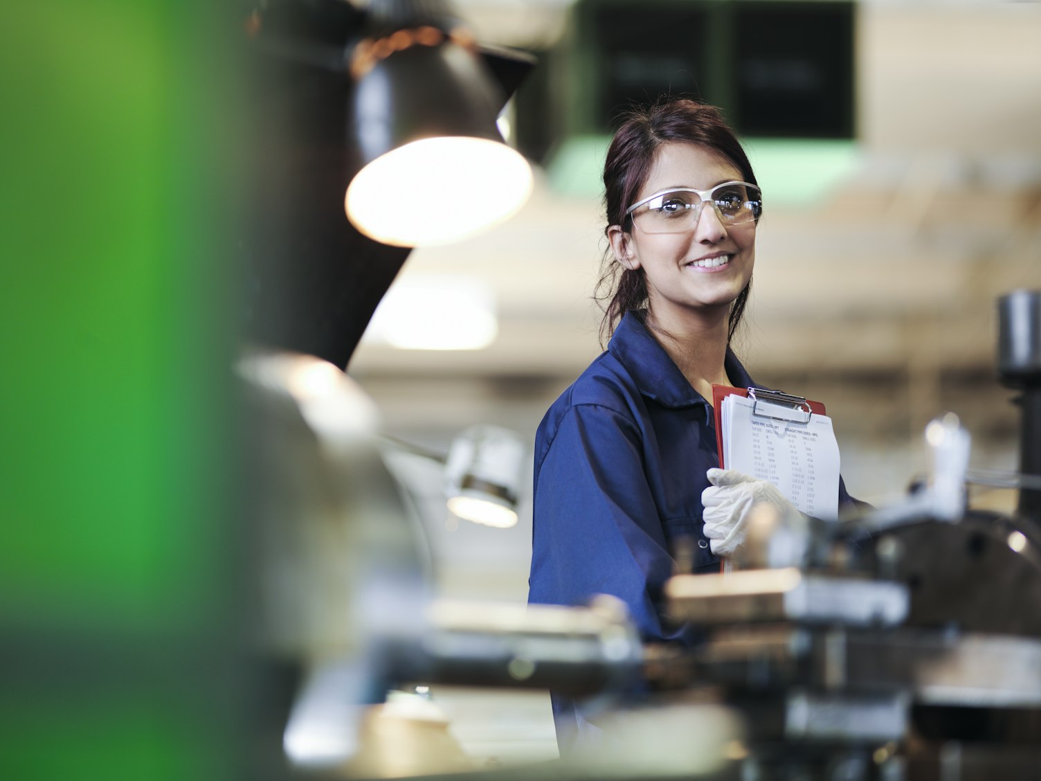 woman working in a factory holding clipboard