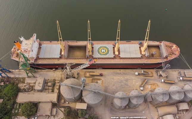 Loading grain into holds of sea cargo vessel in seaport from silos of grain storage Bunkering of dry