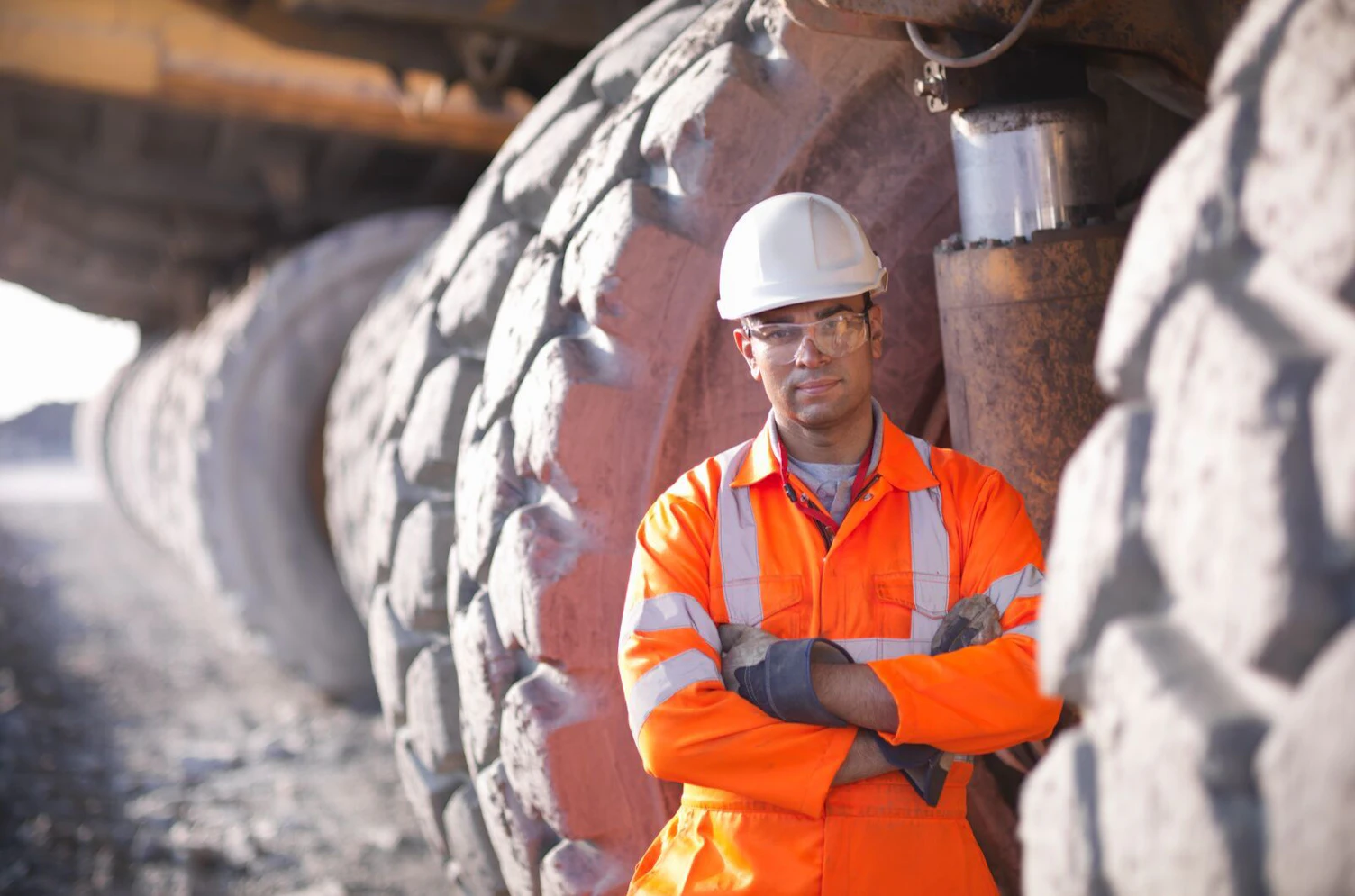 Miner Standing next to a Dumper Truck