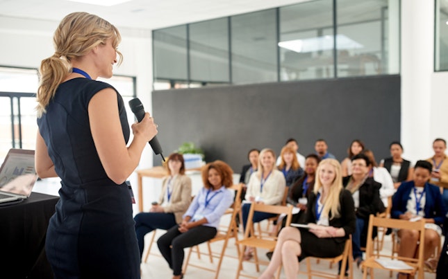 main feature businesswoman delivering a presentation at a conference