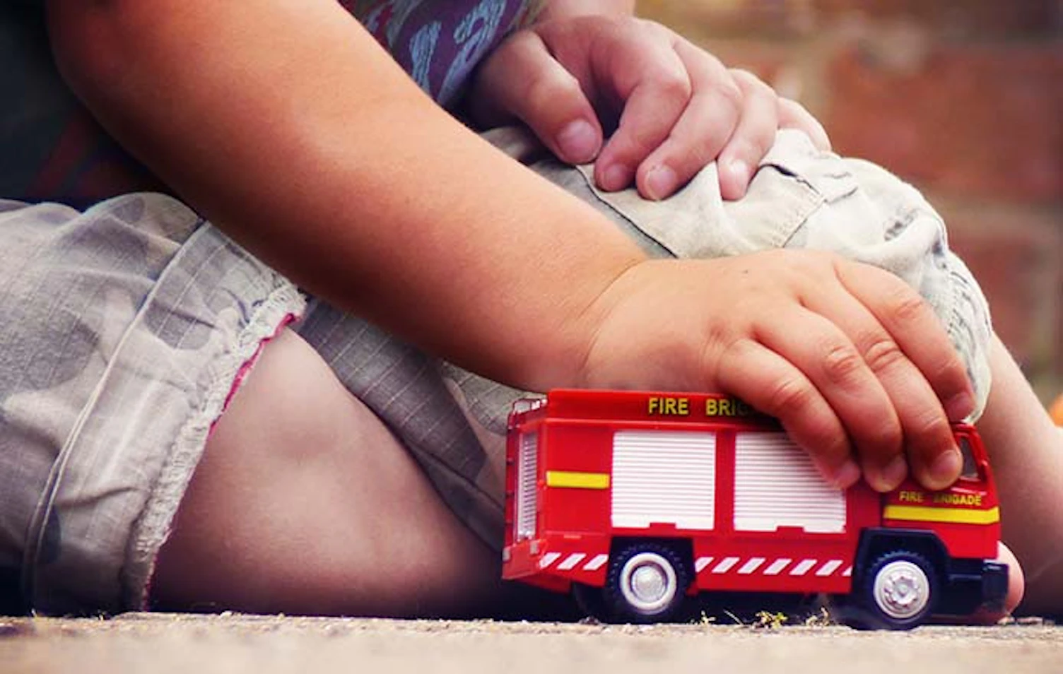 main feature child playing with toy fire truck