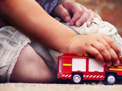 main feature child playing with toy fire truck