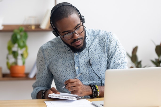 Main Feature Man in Headphones Writing