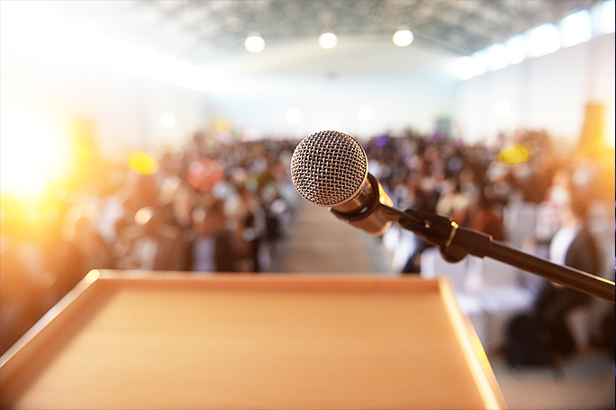 main feature waiting crowd in front of a microphone and podium