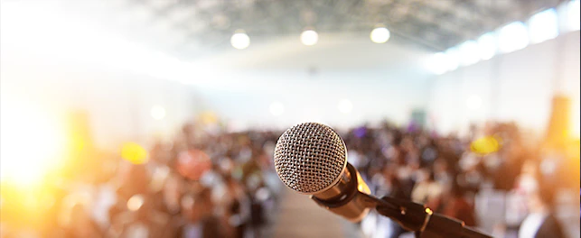 main feature waiting crowd in front of a microphone and podium