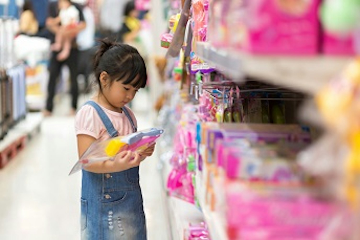 orig Asian girls shopping for toys in department store