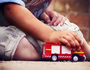 orig boy playing with toy fire truck