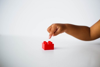 orig child pointing to red building block