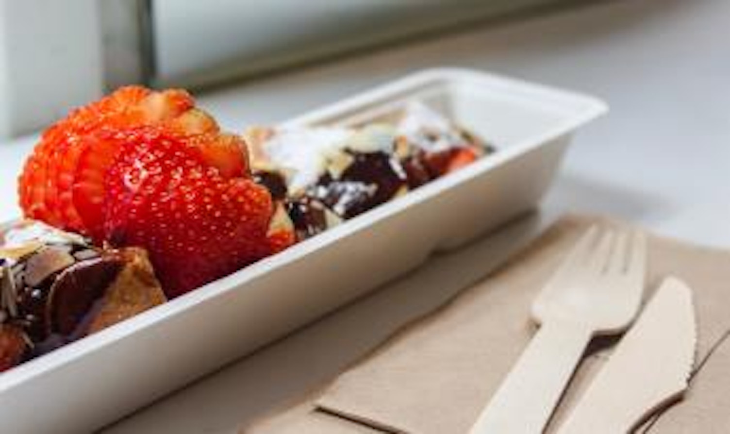 orig desert in a paper tray with wooden cutleriesunsplash